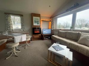 a living room with a couch and a table at 26 The Green Captains Cabin in Crantock