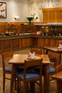 a restaurant with wooden tables and chairs and a kitchen at New Life Piracicaba by Atlantica in Piracicaba