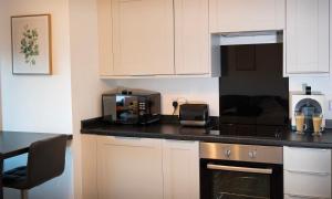 a kitchen with white cabinets and a stove top oven at Rook View in Buckie
