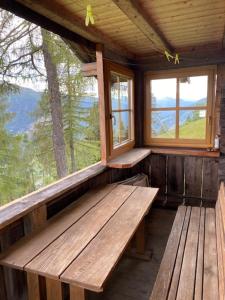 a room with benches and windows in a cabin at Samalmglück in Maria Luggau