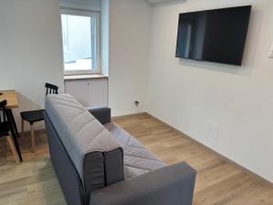 a living room with a couch and a flat screen tv at Casa do práctico in Foz