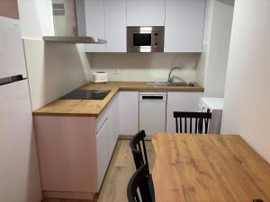 a small kitchen with a table and a microwave at Casa do práctico in Foz
