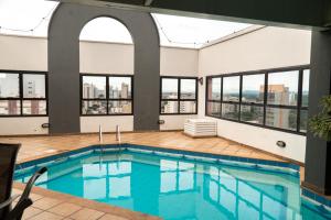 a pool in a building with windows at New Life Piracicaba by Atlantica in Piracicaba