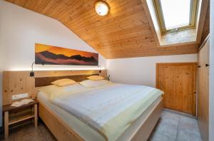 a large bed in a room with a wooden ceiling at Wiesenhäusl in Bischofswiesen