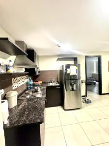 a kitchen with a stainless steel refrigerator in a room at Love Apartment in Guayaquil