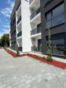 an apartment building with red flowers in front of it at Avram in Vrnjci