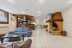 a living room with a blue couch and a fireplace at Hotel Xalet Besolí in Arinsal