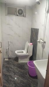 a bathroom with a white toilet and a sink at The 104-H in Faisalabad +20 photos
