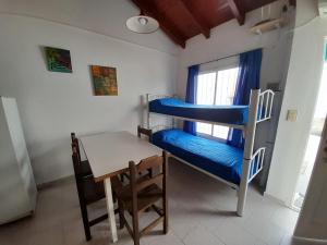 a room with two bunk beds and a table at Departamentos Tere in Las Grutas