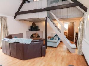 a living room with a couch and a staircase at Stable Cottage in Whitby