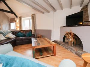 a living room with a couch and a fireplace at Stable Cottage in Whitby