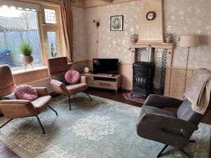 a living room with two chairs and a fireplace at Vakantiehuis Doelestee in Balk +29 photos