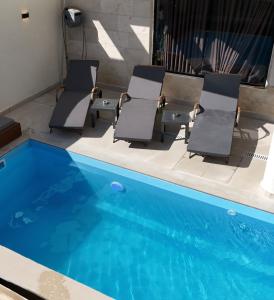 a group of chairs sitting next to a swimming pool at Luxury Duplex With Private Pool in Eilat