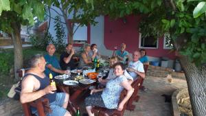 a group of people sitting at a table eating at Ranč Petar Alavanja Banstol in Sremski Karlovci