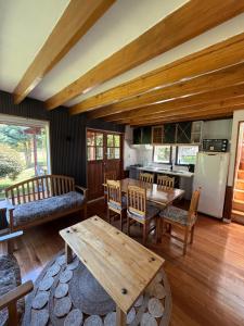 a dining room with a table and a kitchen at Hotel y Cabañas Molino Viejo in Puerto Varas