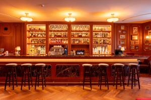 a bar with bar stools in a room at 1904 Benfica Hotel FLH Hotels in Lisbon +37 photos