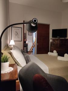 a bedroom with a bed and a couch and a lamp at Malibu in Glyfada