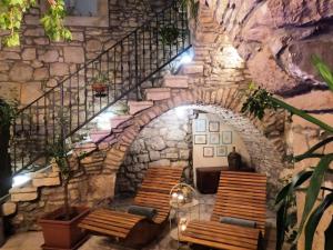 a stairway with wooden benches and a stone wall at Stone House Hedonia in Blato