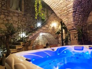 a blue tub in a room with a stone wall at Stone House Hedonia in Blato +65 photos