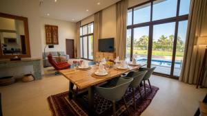 a living room with a wooden table and chairs at Villa Palmview in Salalah