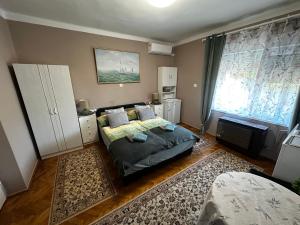 a bedroom with a bed and a large window at RELAX13 Vendégház in Hévíz