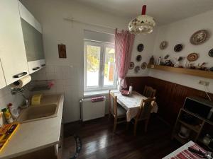 a kitchen with a table and a sink and a window at RELAX13 Vendégház in Hévíz +15 photos