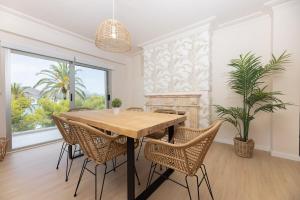 a dining room with a wooden table and chairs at Mar Blau in Port d'Alcudia +12 photos