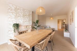 a dining room with a wooden table and chairs at Mar Blau in Port d'Alcudia