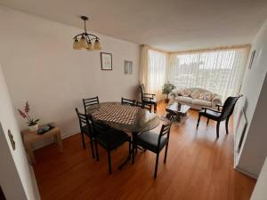 a living room with a table and chairs at Habitaciones con C in Concepción