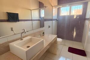 a bathroom with a sink and a mirror at Pousada Casa Shanti in Dourados +63 photos