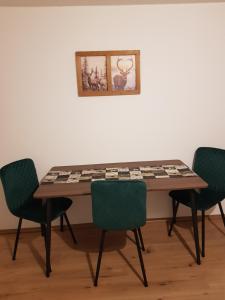 a table with four chairs and a picture on the wall at Haus Flora in Hasselfelde