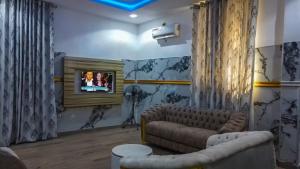 a living room with a couch and a television at Royal Modak Resort & Hotel in Ibadan