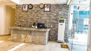 a woman sitting at a counter with a computer at Royal Modak Resort & Hotel in Ibadan