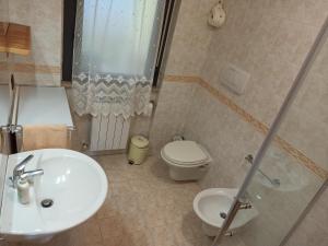 a bathroom with a sink and a toilet and a shower at La Scintilla sul Mare in Marina di Montenero +2 photos