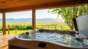a hot tub on a deck with a view of a field at Upscale Hot Tub Wildlife Views in Victor