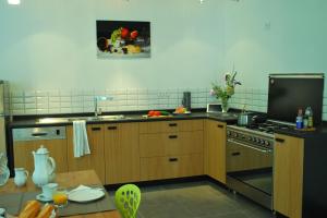 a kitchen with wooden cabinets and a stove top oven at Maison Le Feu Follet in Lormes
