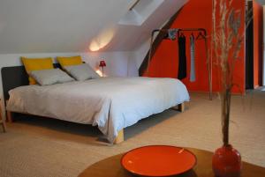 a bedroom with a bed and a vase on a table at Maison Le Feu Follet in Lormes