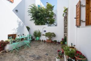 a courtyard with a table and potted plants at Mitsi Studios in Naousa
