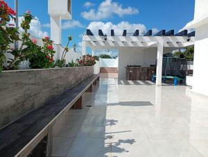 a white pergola and a bench on a patio at Habitaciones Aurelia in Felipe Carrillo Puerto