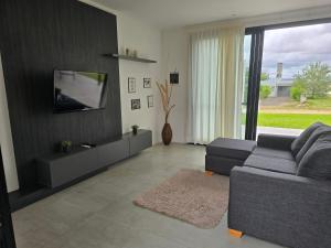 a living room with a couch and a flat screen tv at Lago Santa Ana in Santa Ana