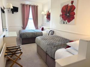 a hotel room with two beds and a window at Dergvale Hotel in Dublin