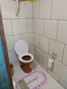 a small bathroom with a toilet and a rug at Recanto Sebold in Guaratuba