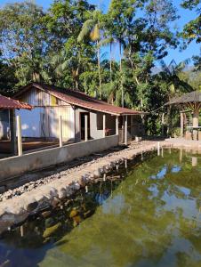 a house with a pond in front of it at Recanto Sebold in Guaratuba