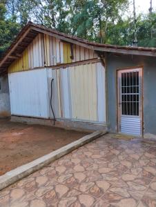a small building with a gate and a garage at Recanto Sebold in Guaratuba