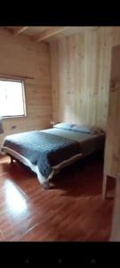 a bedroom with a bed in a wooden room at Cabaña pilina in Pucón