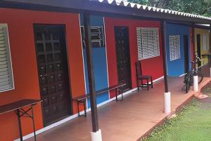 a building with two doors and a deck with benches at Camping e Hostel Internacional in Foz do Iguaçu +9 photos