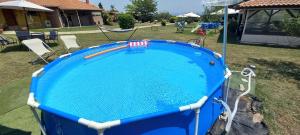 a blue swimming pool in a yard with chairs at Olympos House in Litochoro