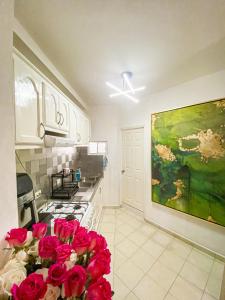 a kitchen with a vase of red roses on the counter at Baja Cabo Hostal Arenal in Cabo San Lucas
