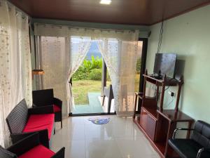 a living room with a large window and a couch at Las Pavitas Arenal Suites in Fortuna