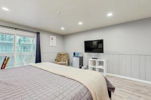 a bedroom with a bed and a flat screen tv at Sea Treasures Inn #207 in Rockaway Beach